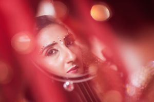 Sona's behind red decor by Resh Rall Wedding Photography, Leeds
