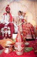 Sona and Amer seated at wedding by Resh Rall Wedding Photography, Leeds